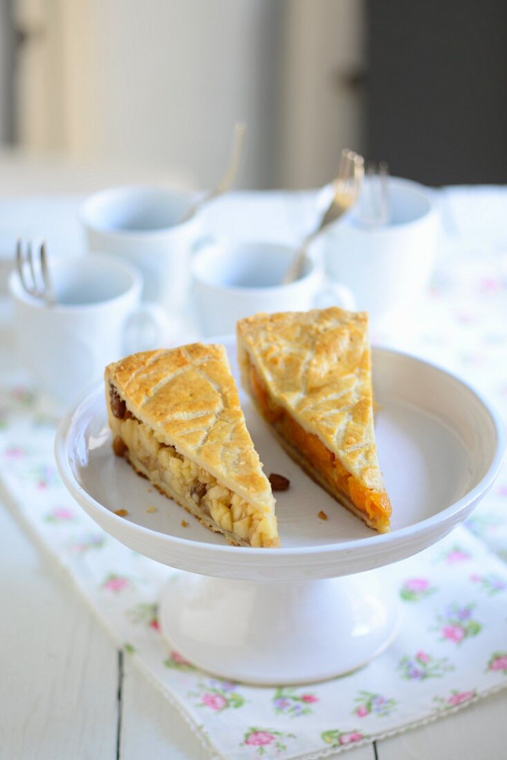 Two different fruit cake pieces on a cake stand