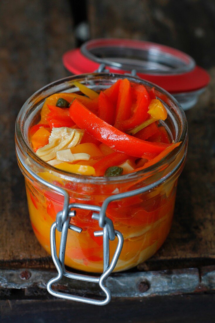 Italian Pickled Peppers in a Jar on a rustic wood background