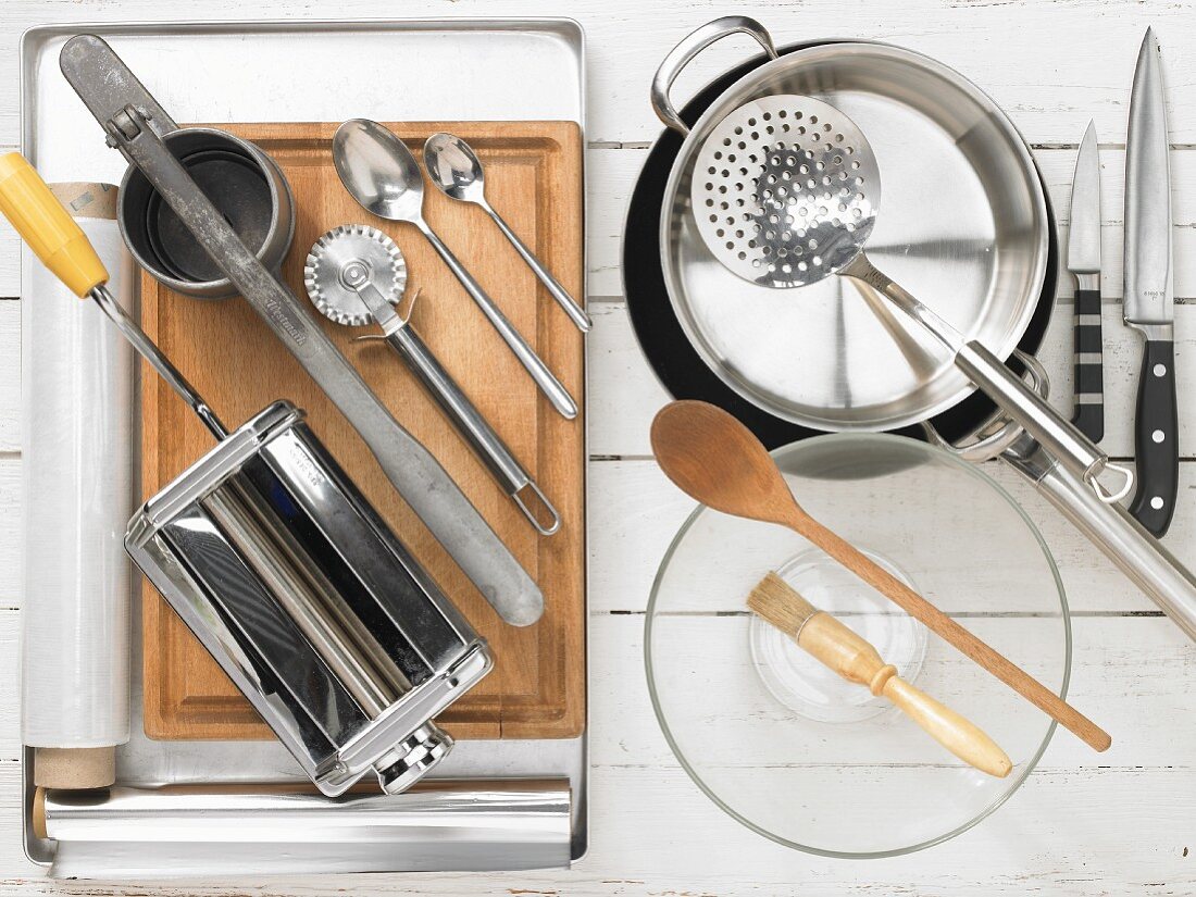 Various kitchen utensils: pasta machine, potato press, pastry wheel, pot, pan