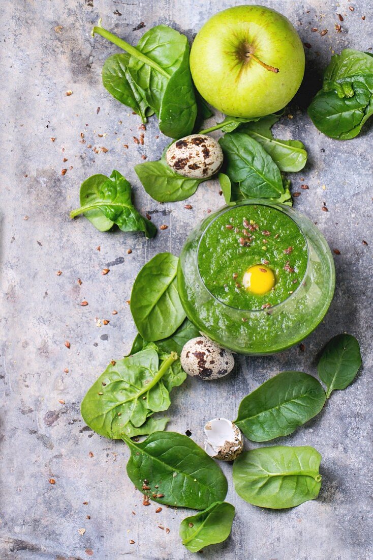 Grüner Smoothie mit Spinat, Apfel und rohem Wachteleigelb (Aufsicht)