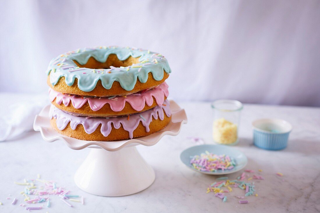 A doughnut cake with three pastel coloured glazes