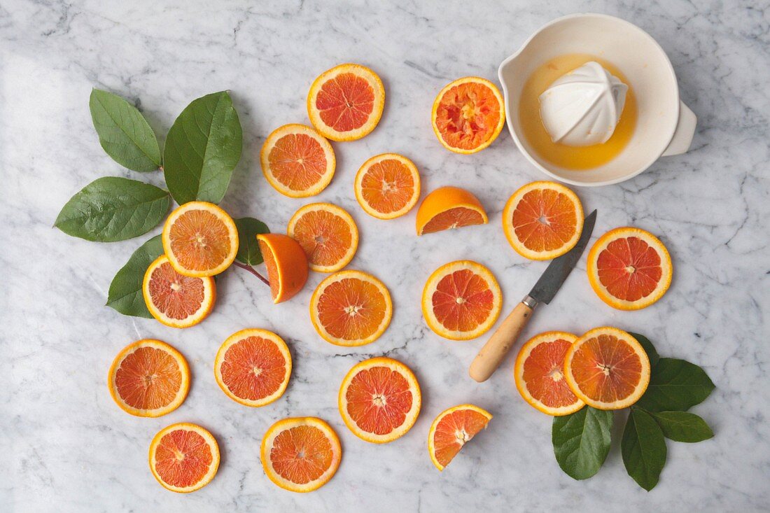 Orange slices with a citrus press on a marble background