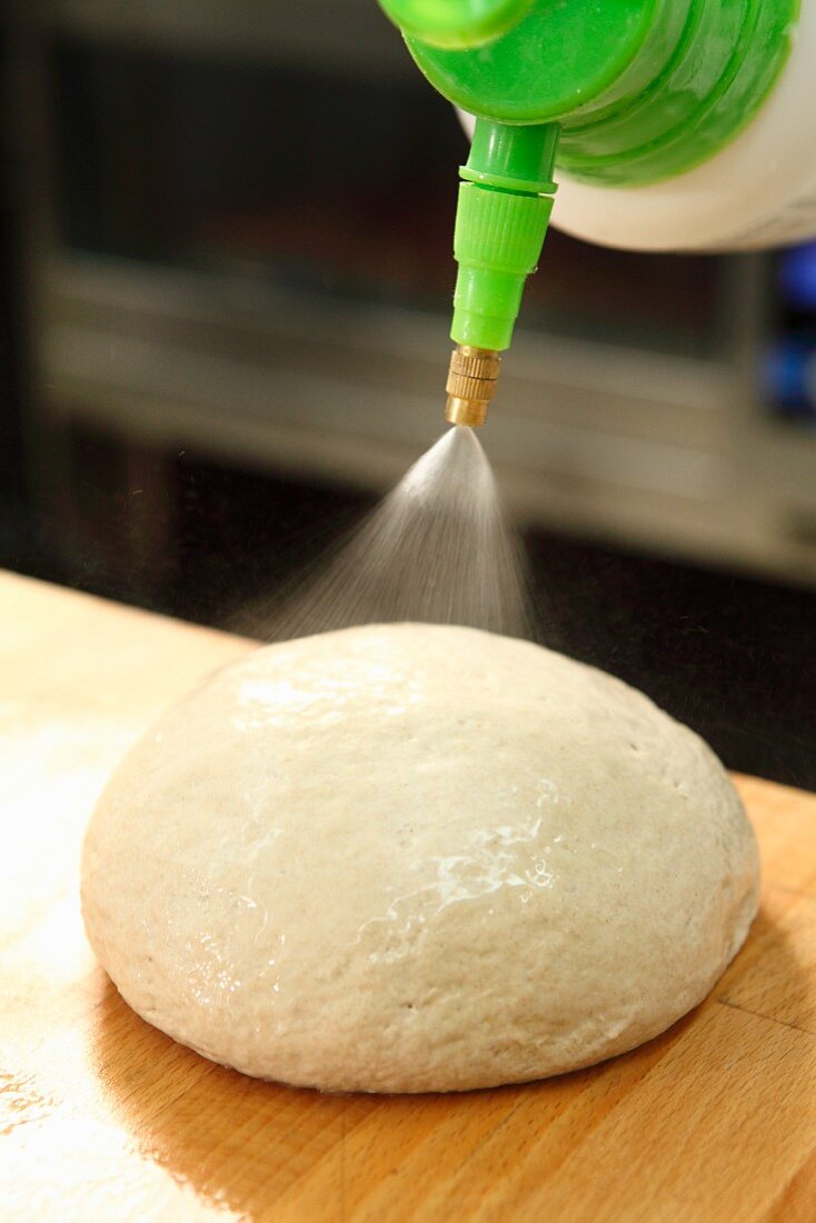 A piece of dough being sprayed with water