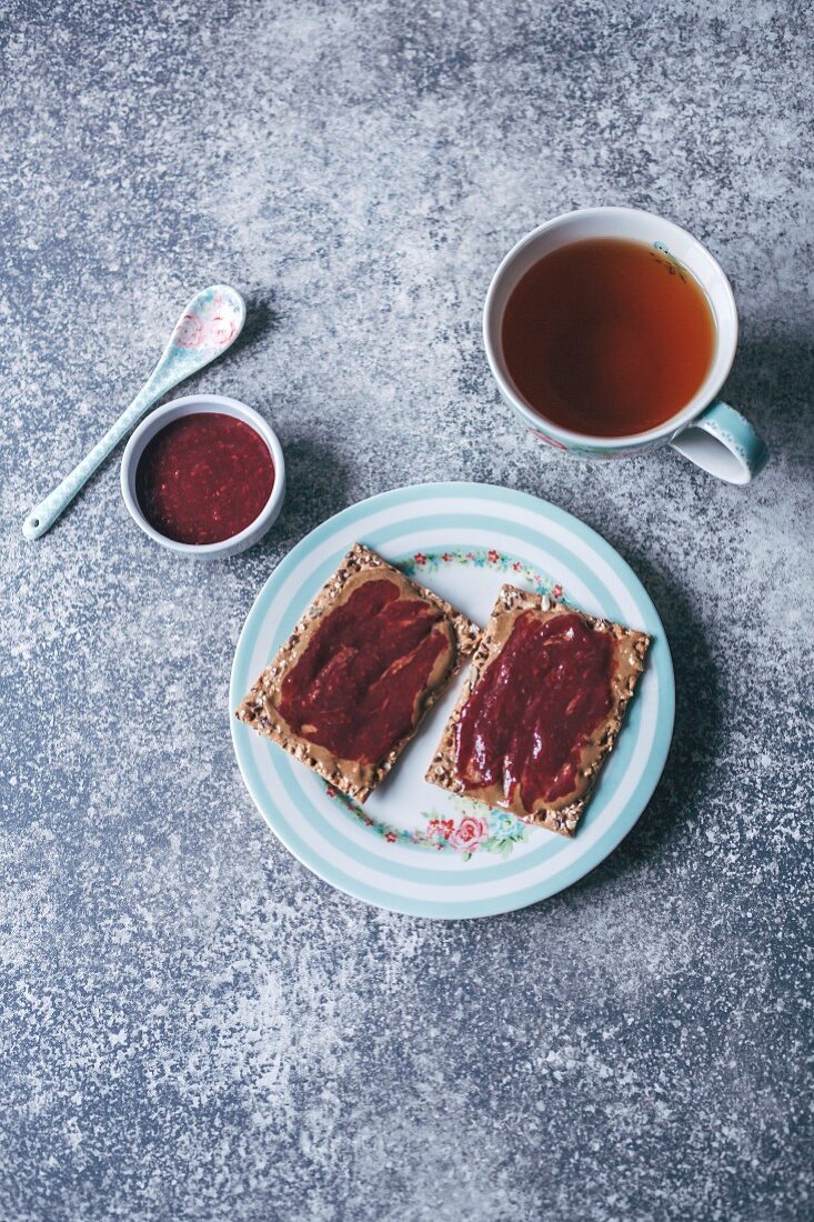 Tahini and raspberry jam on crisp bread and a cup of tea
