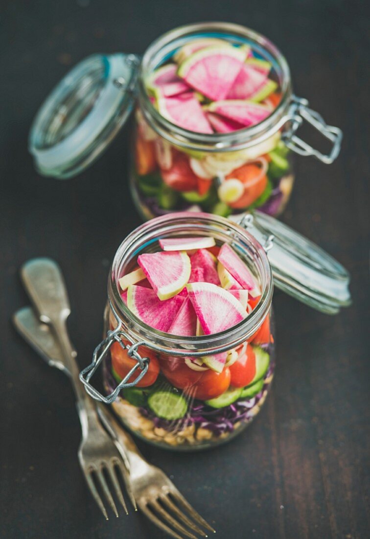 Healthy take-away lunch jars: vegetable and chickpea sprout vegan salad in glass jars