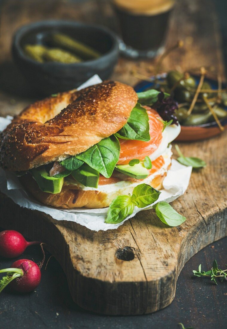 Frühstücksbagel mit Lachs, Avocado, Frischkäse und Basilikum