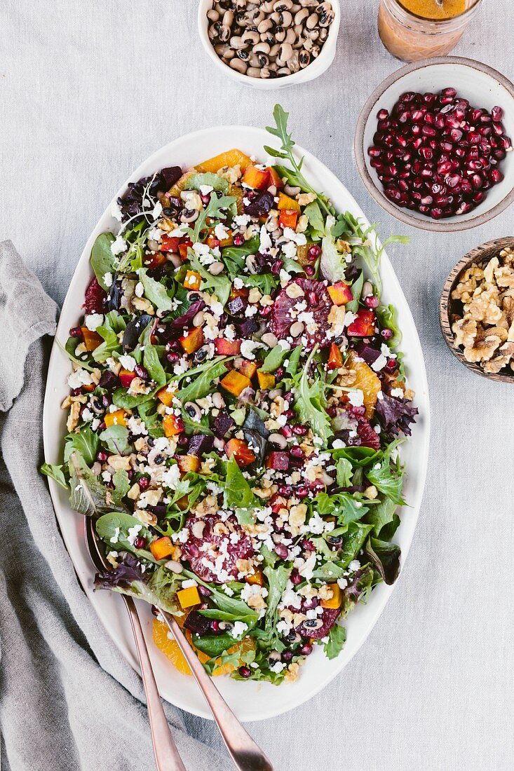 Salat mit Rote-Bete, Zitrusfrüchten, Augenbohnen und Ziegenkäse auf Servierplatte