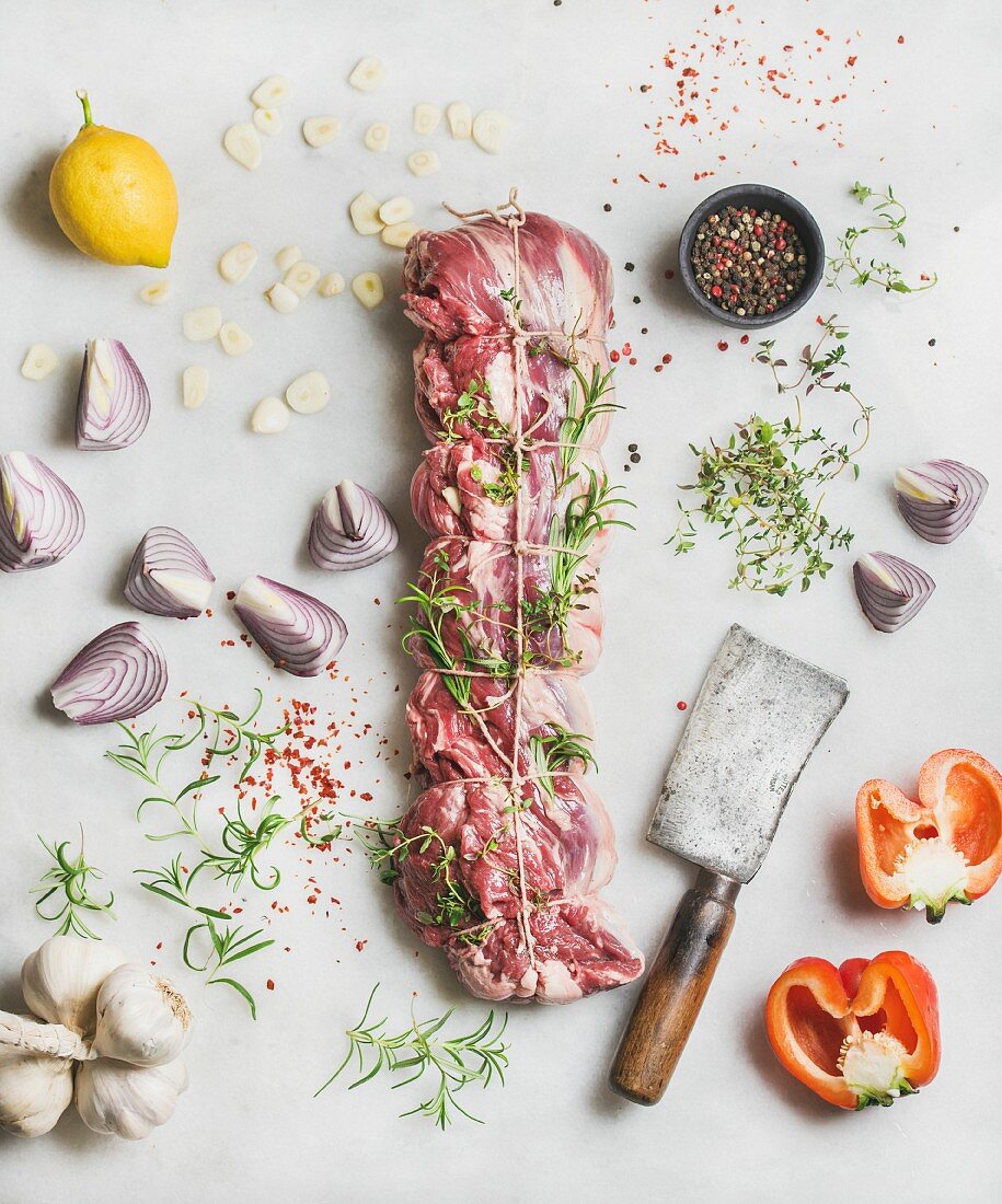 Raw uncooked roast beef meat cut with herbs, vegetables and spices, top view