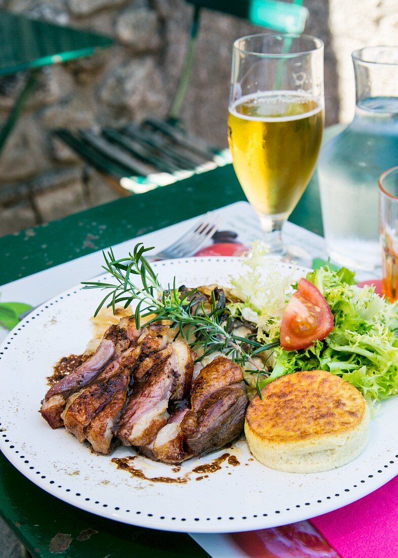Grilled duck breast with rosemary and salad on a restaurant table