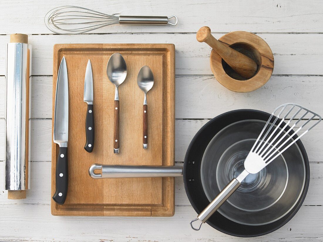 Kitchen utensils: mortar, pan, spatula, aluminium foil, whisk, knives