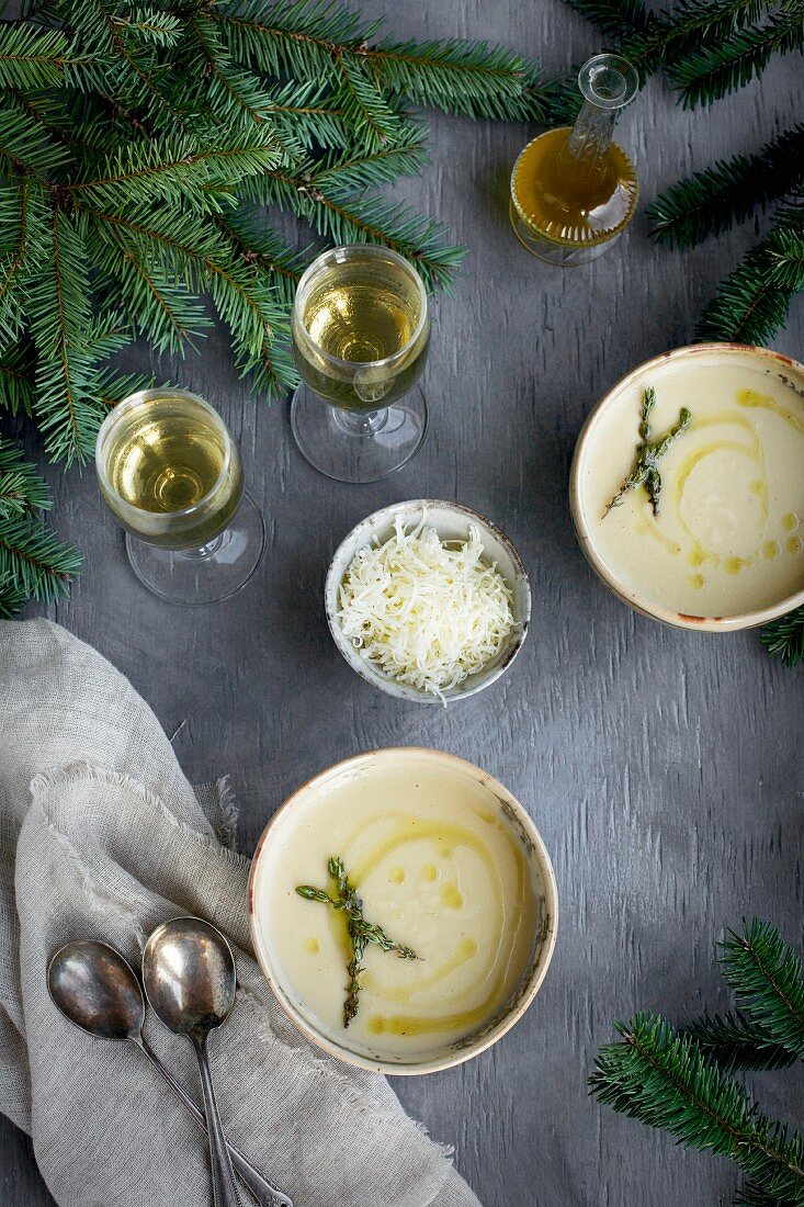 Asiago White Bean Soup with Thyme Oil served in ceramic bowls with white wine on a gray background