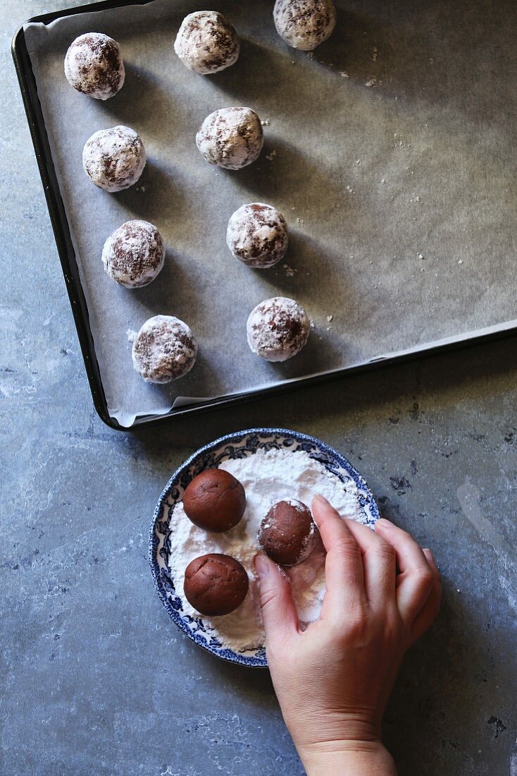 Chocolate Crinkle Cookies werden in Puderzucker gewälzt