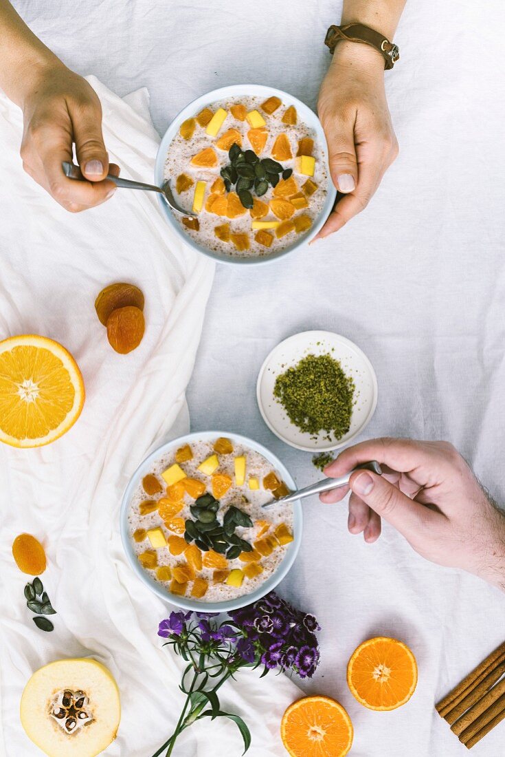 A woman and a man having bulgur cooked in cinnamon flavored milk for breakfast, top view