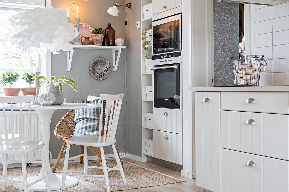 Round table in white country-house-style kitchen-dining room