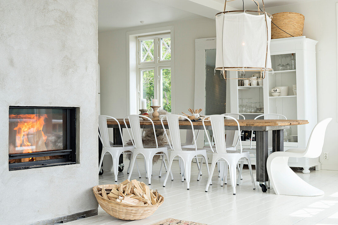 Long table in pale dining room with fireplace