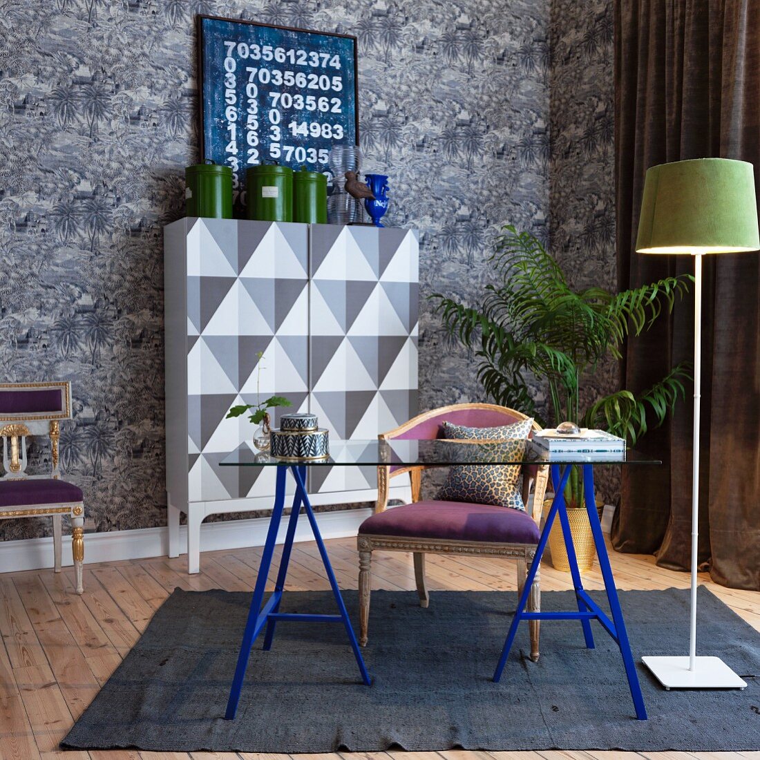 Desk with blue legs and wallpaper with graphic pattern