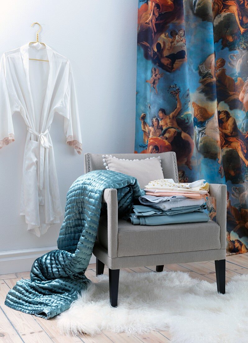 Dressing corner in white room with blue blanket and bed linen on chair