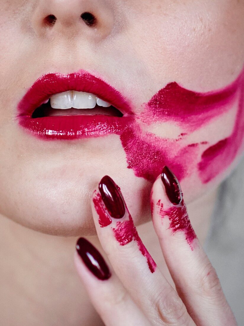Close-up of a mouth smeared with lipstick