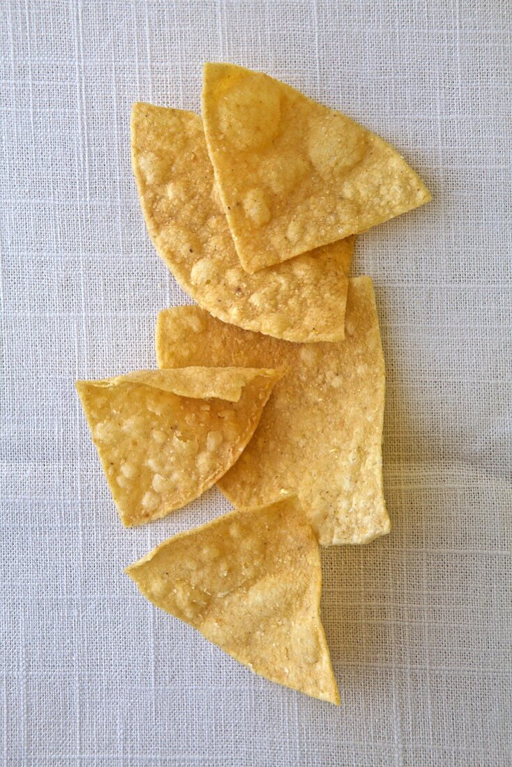 Mehrere Tortillachips auf weißem Untergrund (Aufsicht)