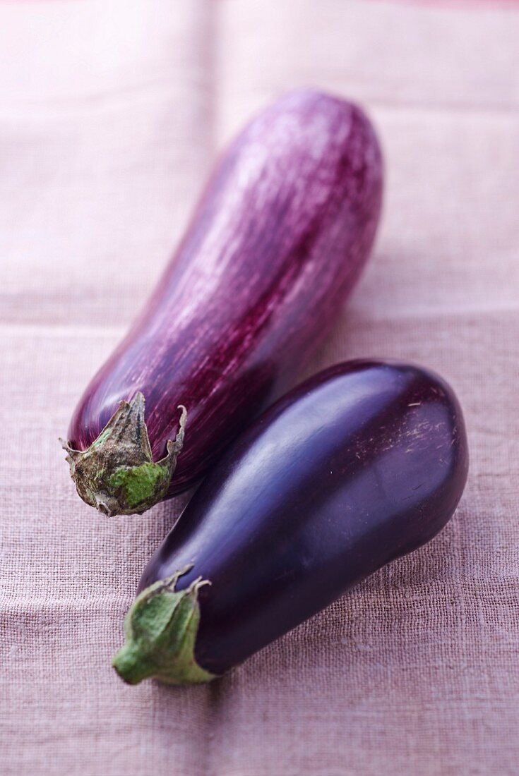 Two aubergines on a linen cloth