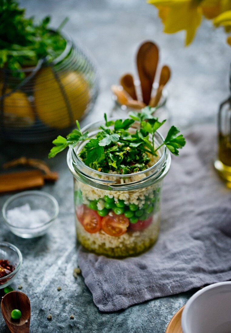 Millet salad with tomatoes and peas in a glass jar