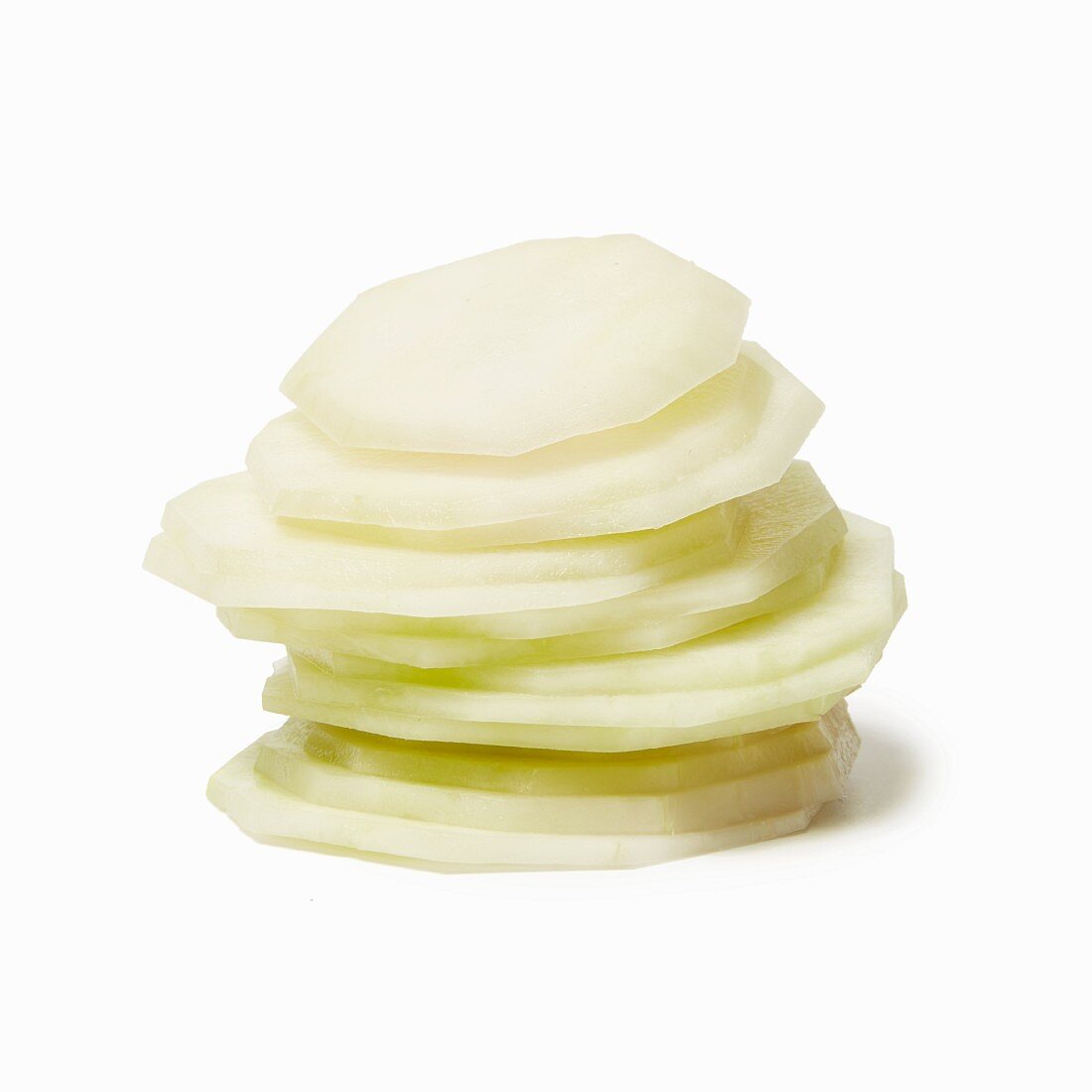 A stack of kohlrabi slices in front of a white background