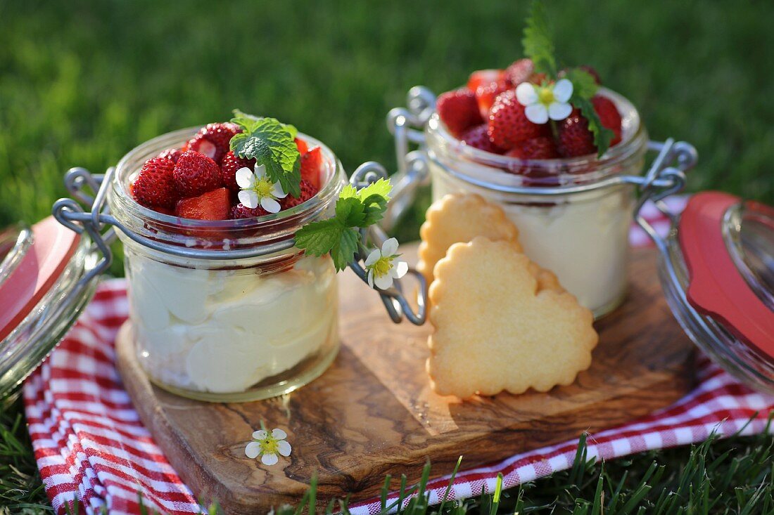 Zitronen-Vanille-Mascarpone-Creme im Glas mit frischen Erdbeeren und Herzkeksen