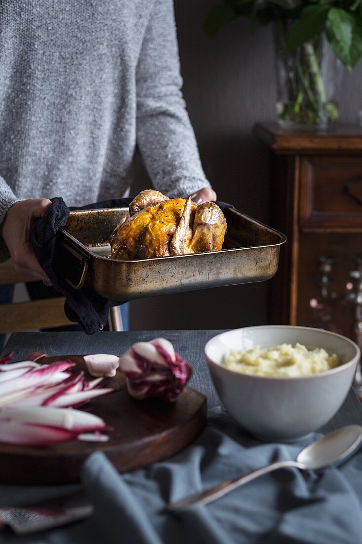 Woman serving roast chicken in pure