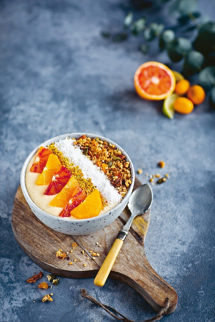 A smoothie bowl with citrus fruits and coconut flakes