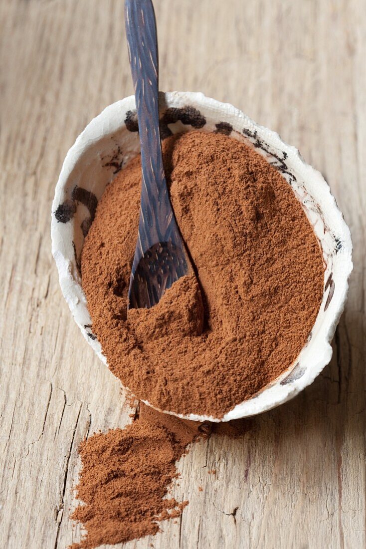 Cinnamon powder in a bowl with a spoon