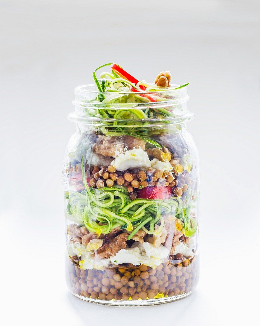 Vegetable salad with lentils and courgette in a glass jar
