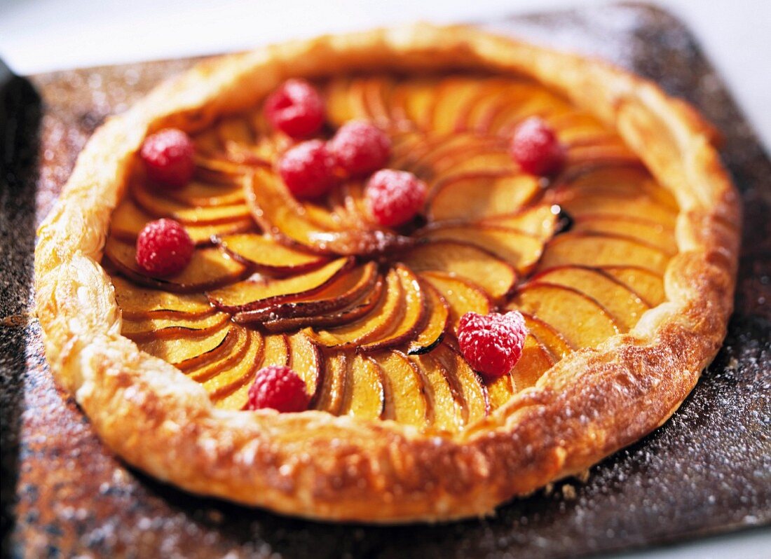 A whole french apple tart on a baking tray