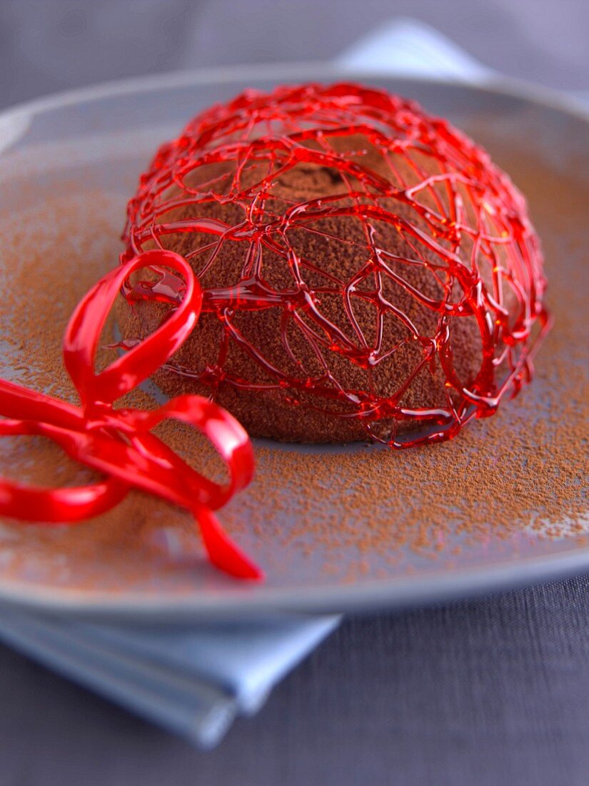 Kupelförmiges Schokoladeneisdessert unter rotem Zuckergespinst