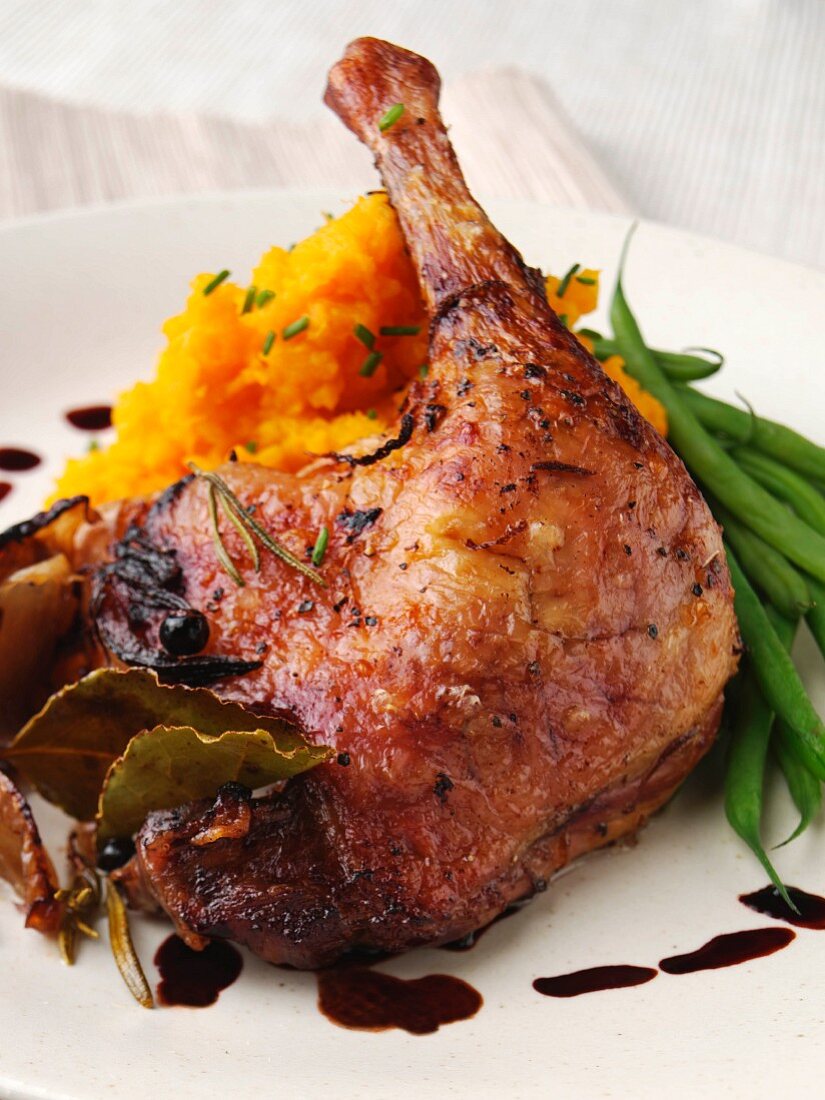 A roast duck leg with mashed swede