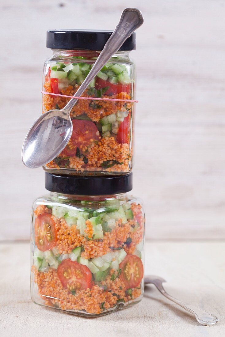 Bulgur wheat salad with pomegranate syrup, onions, cucumber, tomatoes, parsley and mint in a glass jar