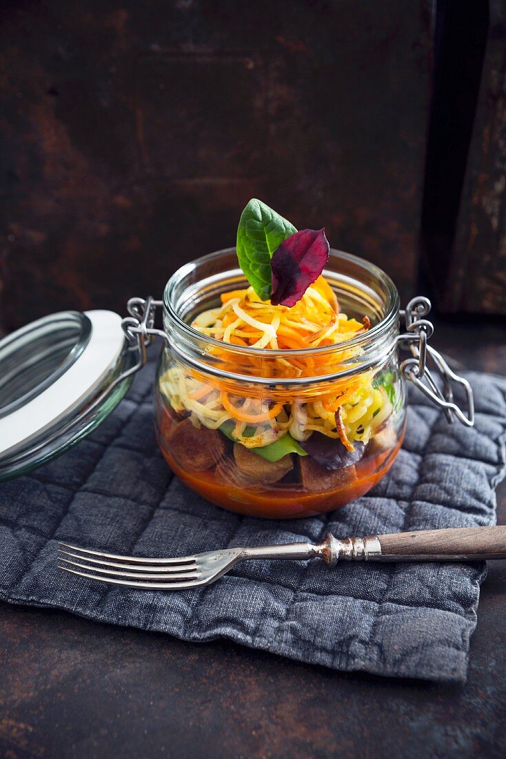 Vegane Tofu-Seitan-'Currywurst' mit zweierlei Pommesspiralen und Salat im Glas