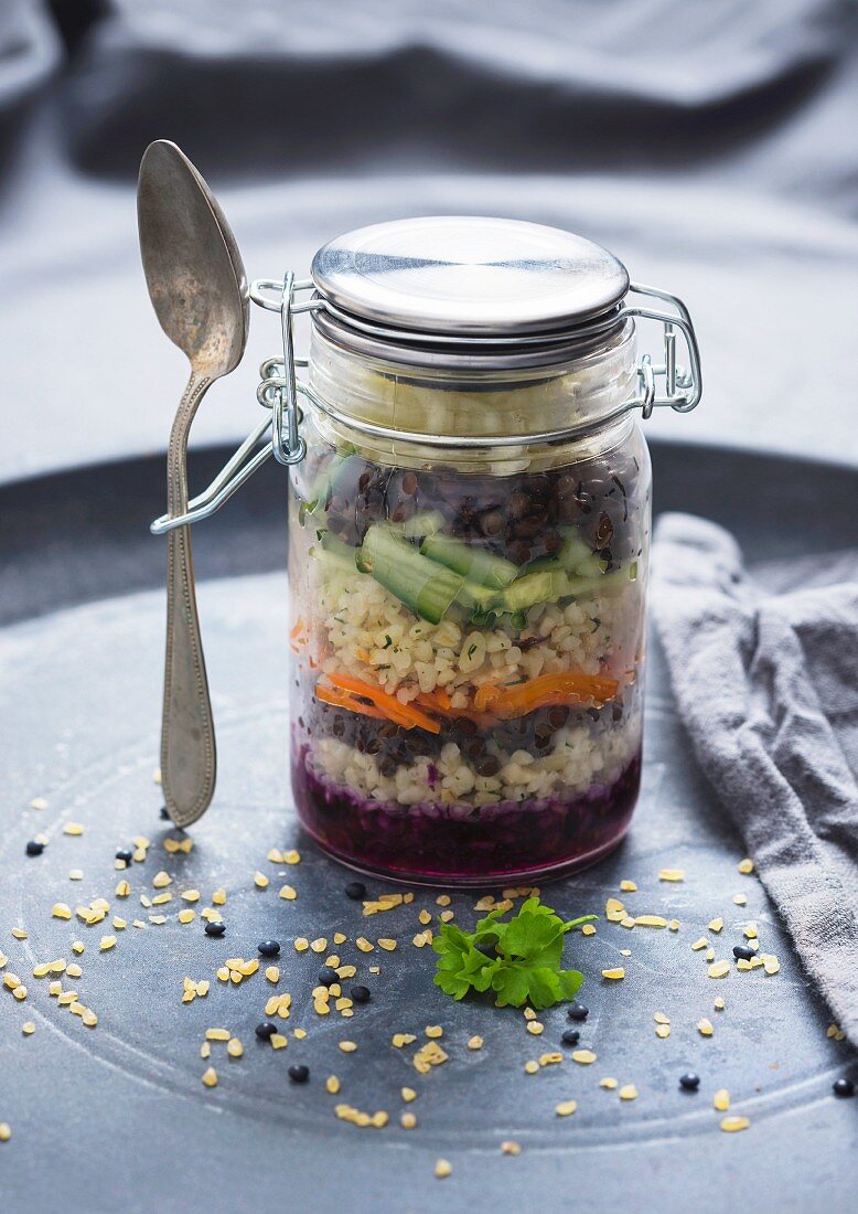 Cabbage salad with carrots, cucumber, bulgur wheat and beluga lentils in a glass jar (Vegan)