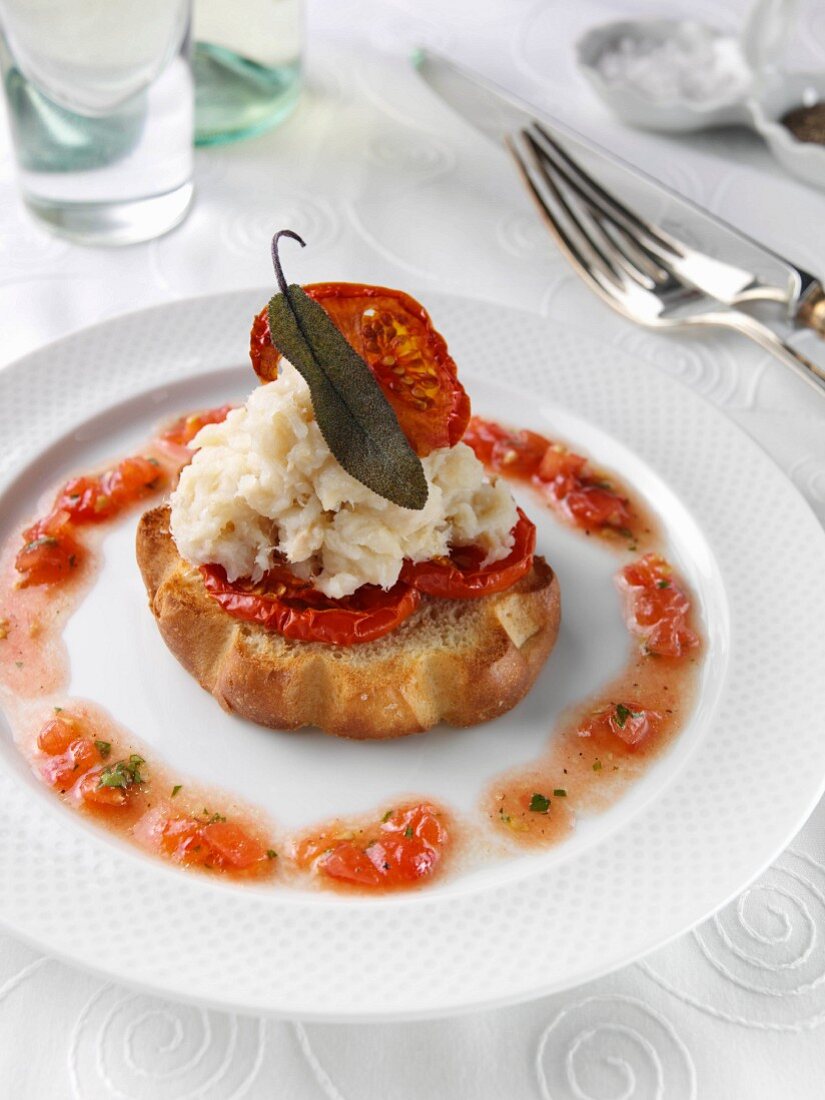 Brandade of salted cod on a slice of brioche in a restaurant table setting