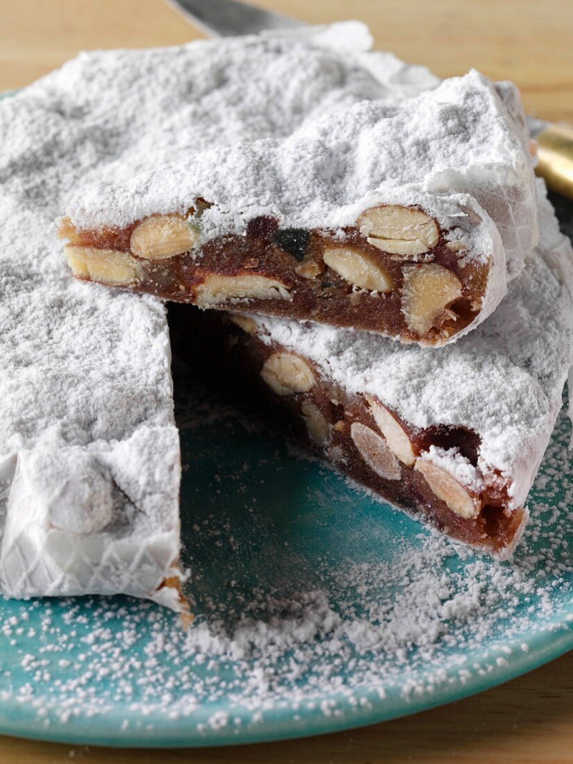 A whole Italian panforte cake with a slice on top