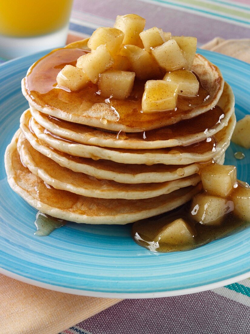 Ein Stapel Pancakes mit Apfelstückchen und Honig