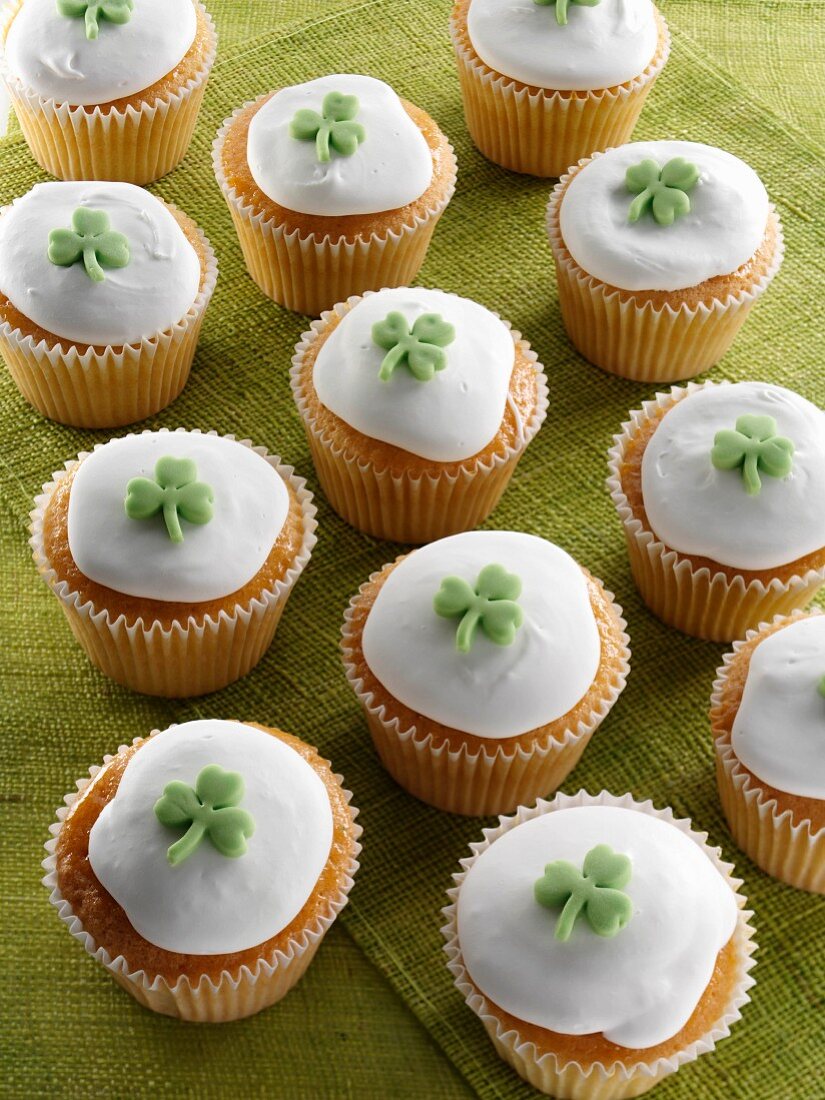 Cupcakes dekoriert mit Zuckerglasur und grünem Fondant-Kleeblatt