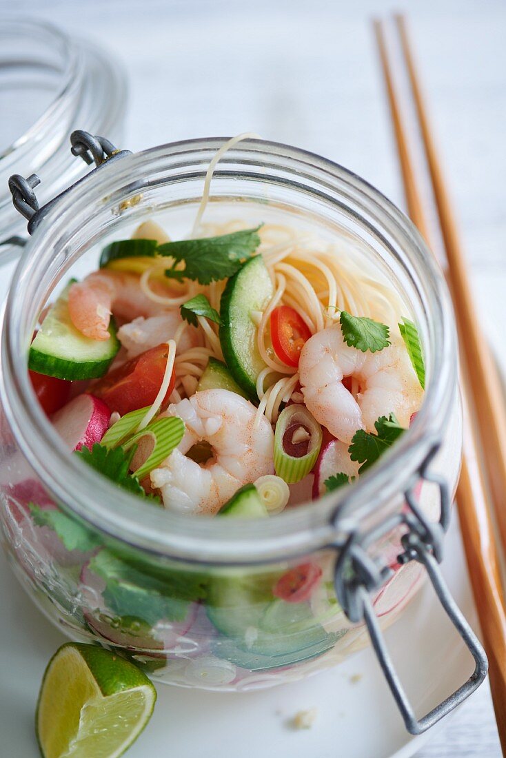 A noodle salad with radishes and shrimps in a glass jar