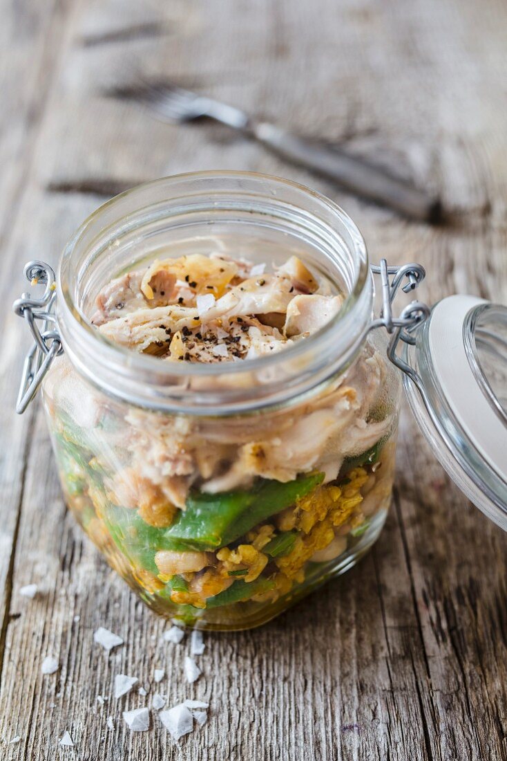 Saffron rice salad with chicken and beans in a glass jar
