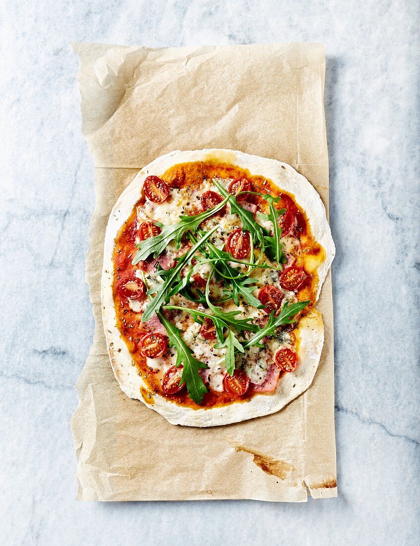 Rustikale dünne Pizza mit Gorgonzola, Schinken und Kirschtomaten