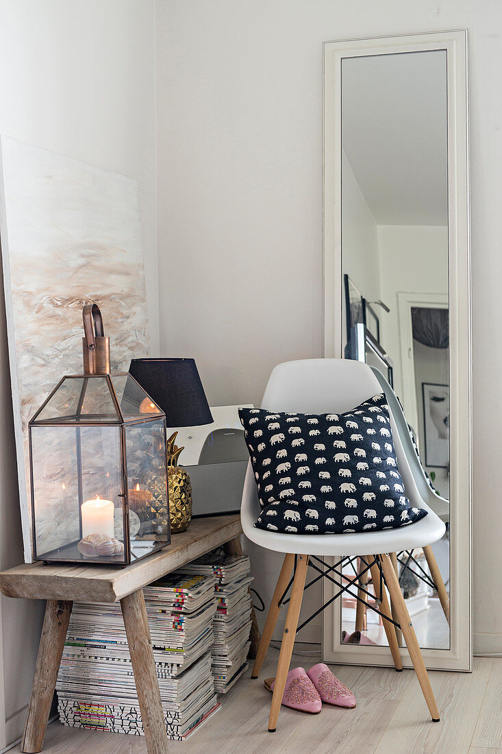 Chair and full-length mirror next to wooden bench and stacked magazines