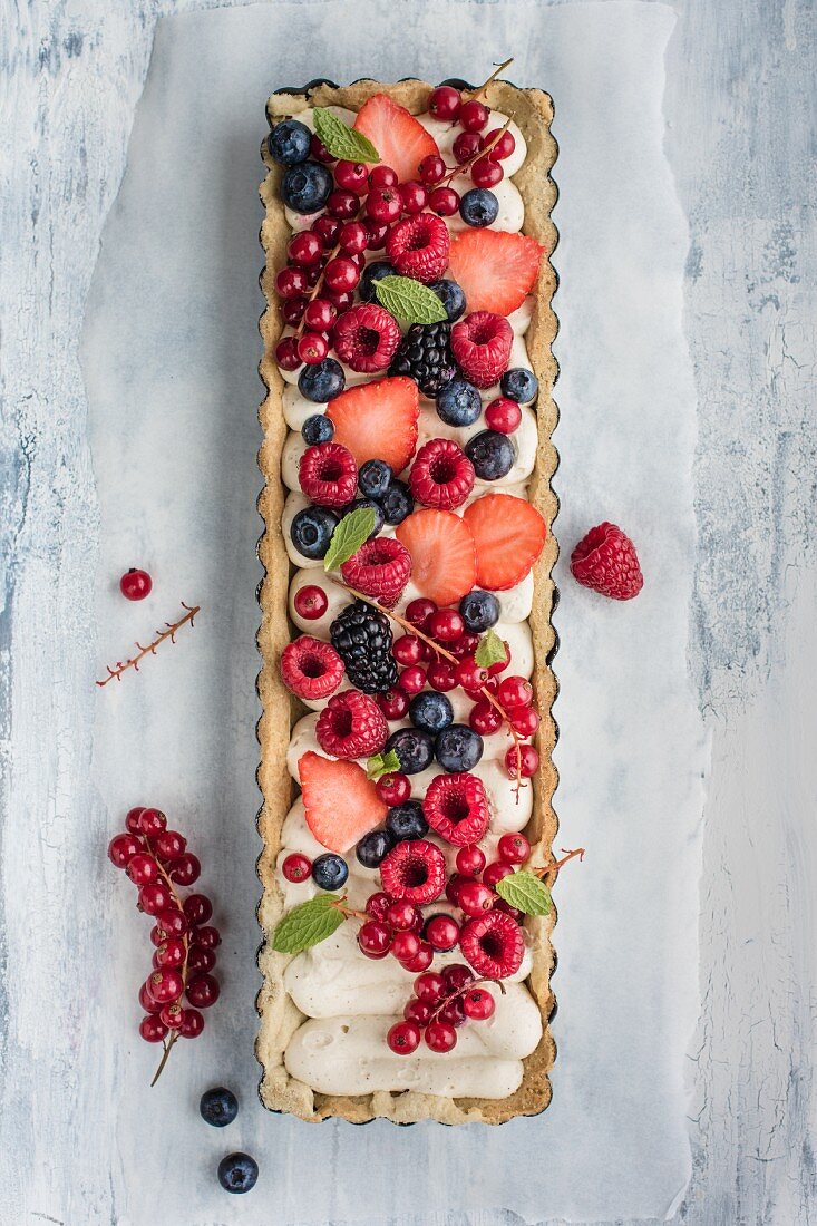 Tart with mascarpone cream filling and red berries, view from above