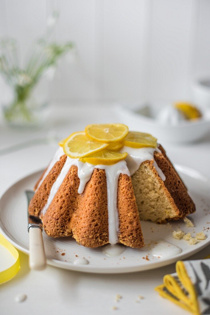 Zitronen-Biskuitkuchen mit Zitronenglasur und frischen Zitronenscheiben