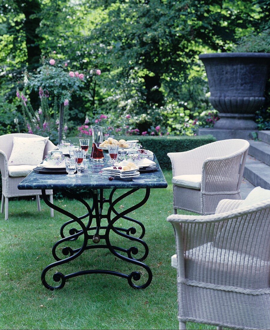 Sommerlicher Sitzplatz mit gedecktem Tisch im Garten