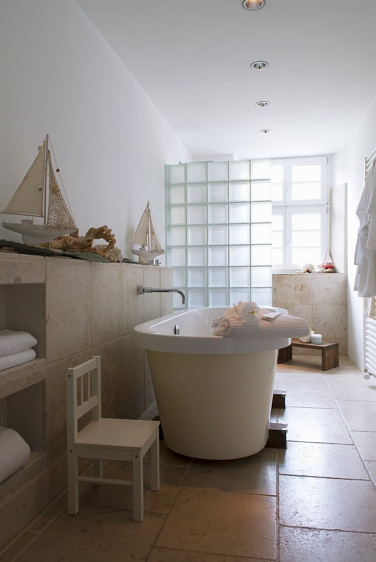 Free-standing bathtub in cream bathroom