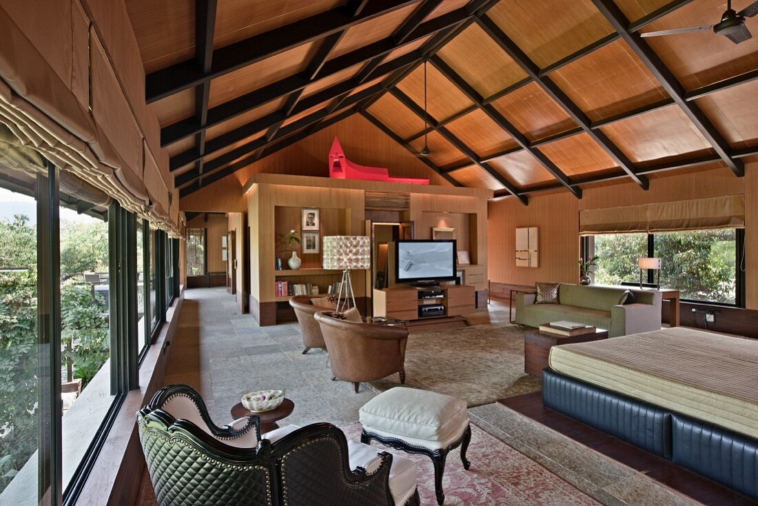 Wood-clad room with exposed roof structure and panoramic windows